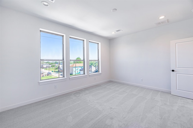 unfurnished room featuring light carpet