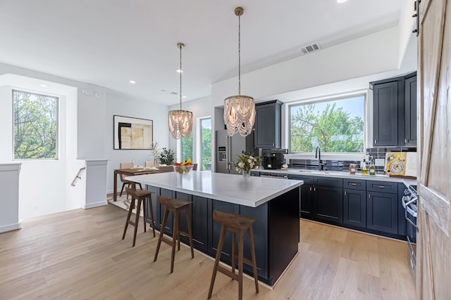 kitchen with a wealth of natural light, a chandelier, a kitchen island, and a barn door