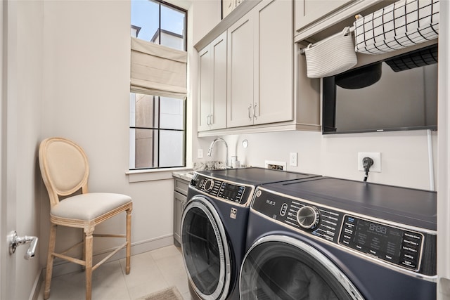 laundry area with washer and dryer, cabinets, and light tile patterned floors