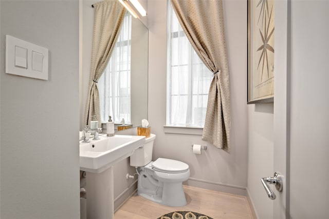 bathroom featuring wood-type flooring and toilet