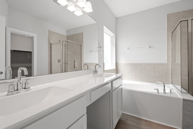 bathroom with vanity, shower with separate bathtub, and wood-type flooring