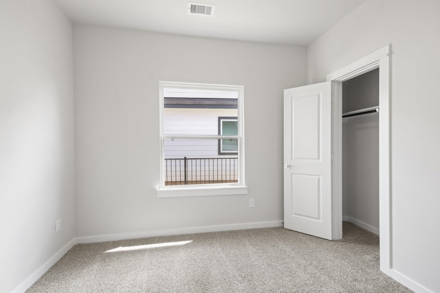 unfurnished bedroom with light carpet and a closet