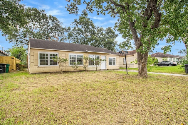 back of property with a yard and fence