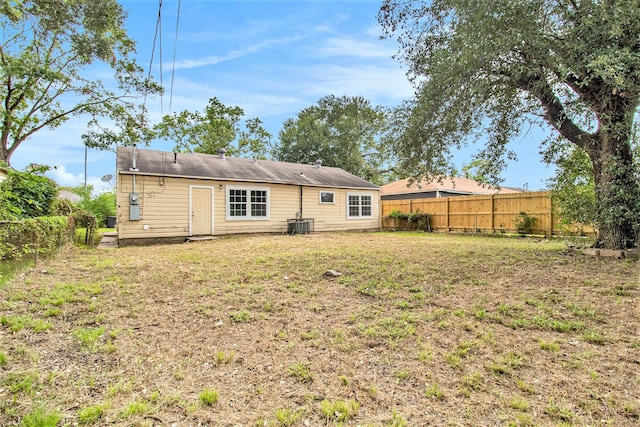 back of property with a lawn and central AC unit