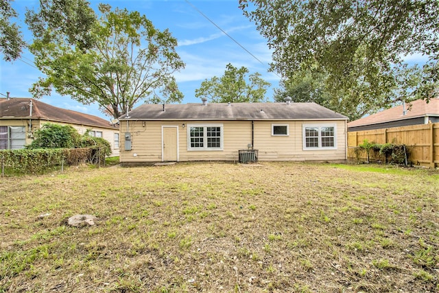 back of house featuring central AC and a yard