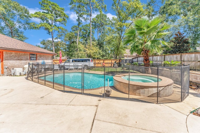 view of swimming pool featuring a patio and an in ground hot tub