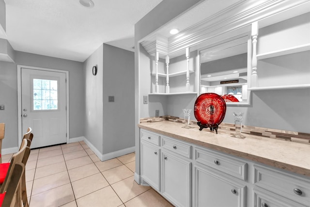 kitchen featuring light tile patterned floors and white cabinetry