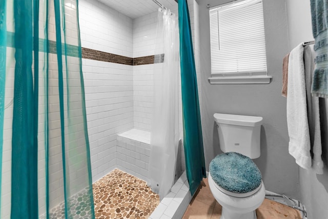 bathroom featuring toilet, walk in shower, and tile patterned floors