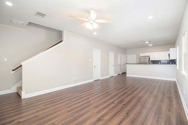 unfurnished living room with dark hardwood / wood-style flooring and ceiling fan