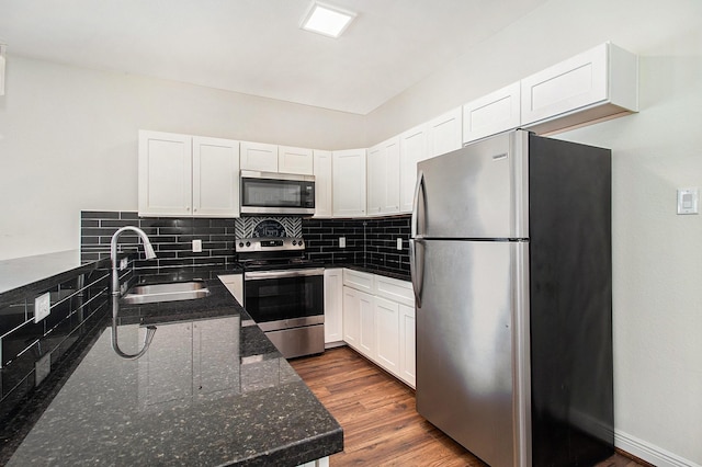 5005 Mallow St A/B, Unit A/B Houston, TX 77033 - kitchen with appliances with stainless steel finishes, a sink, decorative backsplash, and white cabinetry