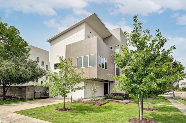 modern home featuring a front lawn