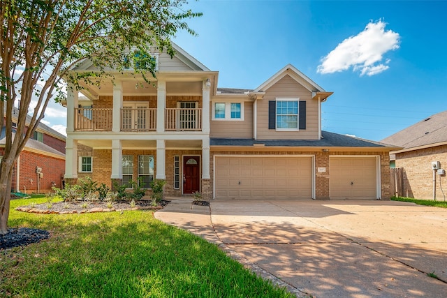 view of front of property featuring a front yard, a balcony, and a garage