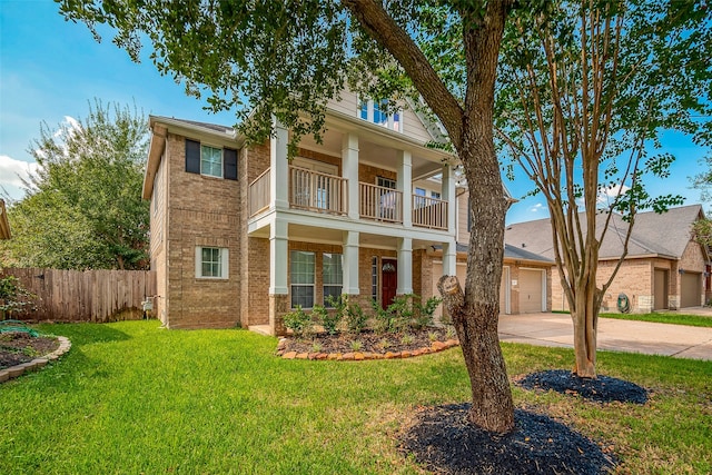 greek revival inspired property with a balcony and a front yard