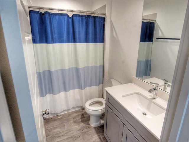 bathroom with vanity, toilet, curtained shower, and hardwood / wood-style flooring