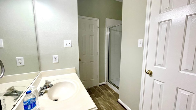 bathroom with vanity, hardwood / wood-style flooring, and a shower with door