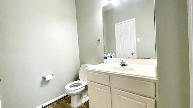 bathroom with hardwood / wood-style floors, toilet, and vanity