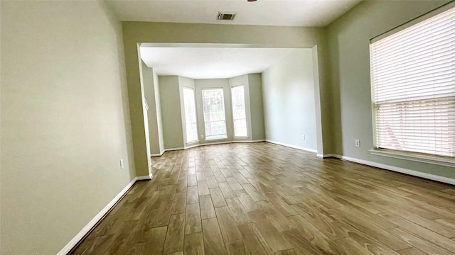 spare room featuring hardwood / wood-style floors and plenty of natural light