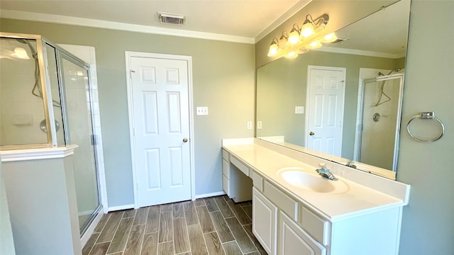 bathroom featuring crown molding, vanity, hardwood / wood-style flooring, and a shower with shower door