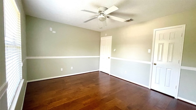 unfurnished room featuring dark wood-type flooring and ceiling fan