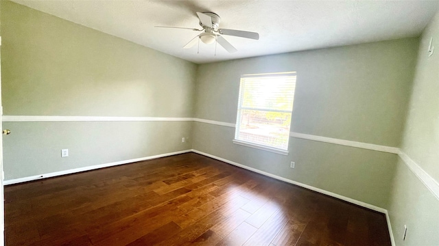 spare room with ceiling fan and dark hardwood / wood-style flooring