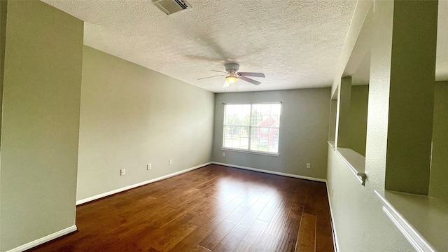 spare room featuring ceiling fan, dark hardwood / wood-style flooring, and a textured ceiling