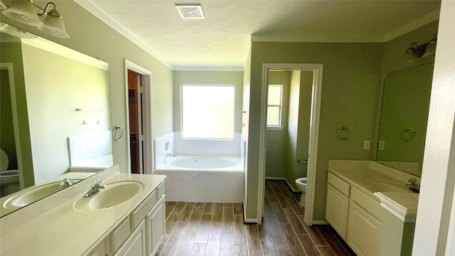 bathroom featuring hardwood / wood-style flooring, toilet, a bathing tub, vanity, and a textured ceiling