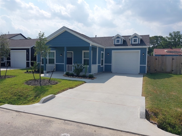 view of front of house with a garage, a front lawn, and a porch