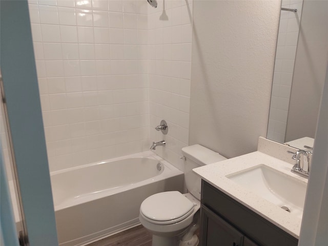 full bathroom featuring tiled shower / bath, vanity, toilet, and hardwood / wood-style floors