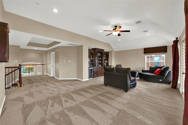 carpeted living room featuring ceiling fan, a raised ceiling, and beverage cooler