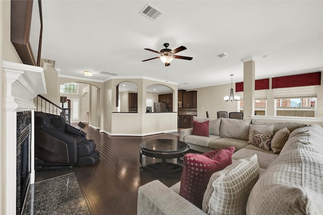 living room with a premium fireplace, hardwood / wood-style floors, a healthy amount of sunlight, and ornamental molding