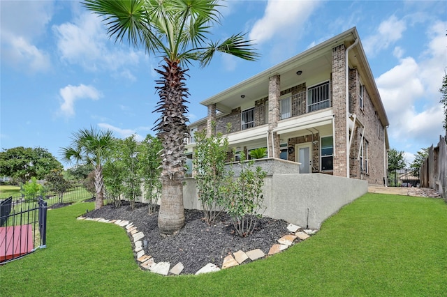 back of property featuring a yard and a balcony