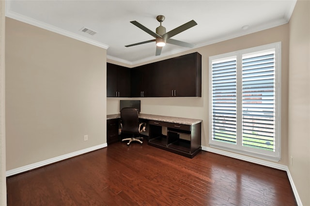 office with ornamental molding, built in desk, dark wood-type flooring, and a healthy amount of sunlight