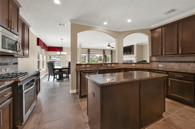 kitchen with backsplash, sink, a center island, and appliances with stainless steel finishes