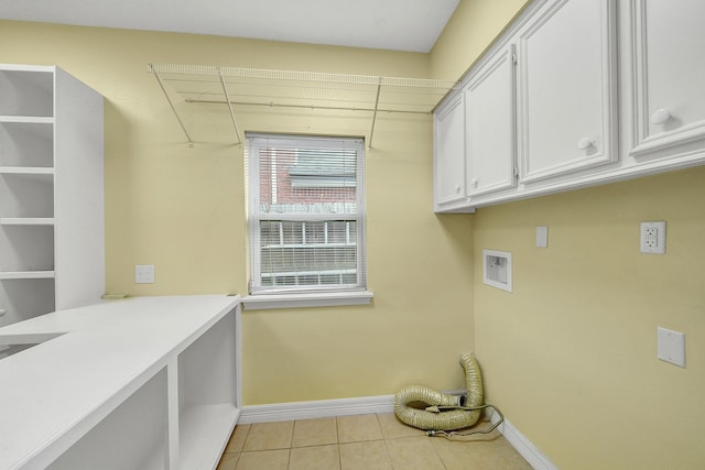 clothes washing area featuring cabinets, washer hookup, and light tile patterned floors