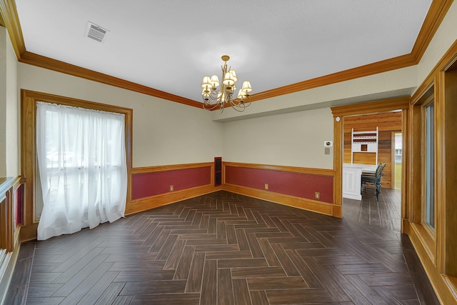 spare room featuring dark parquet floors, an inviting chandelier, and ornamental molding