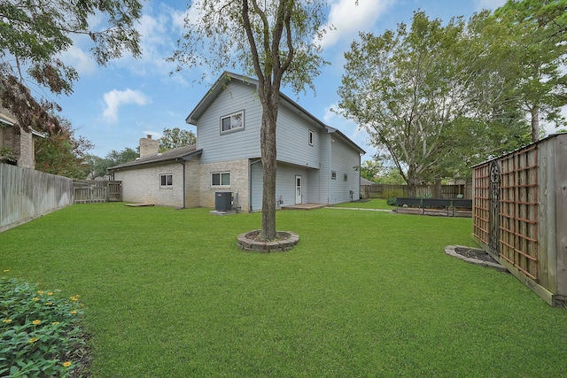 rear view of house featuring a yard and central AC unit