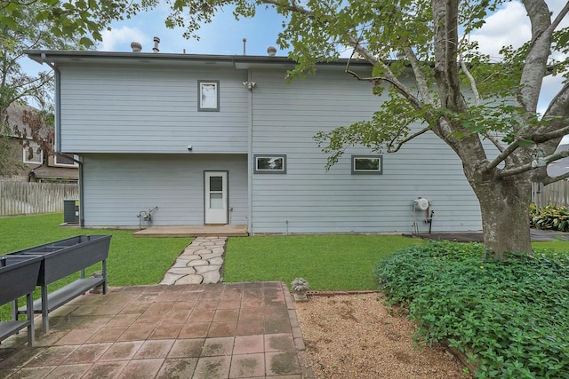 rear view of house featuring a patio area and a yard