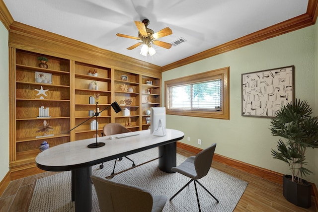 office space with built in features, ceiling fan, and crown molding