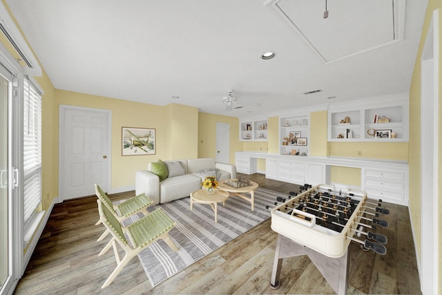 game room with ceiling fan, built in features, and hardwood / wood-style floors