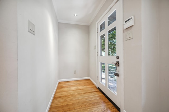 doorway to outside featuring a wealth of natural light, ornamental molding, and light wood-type flooring