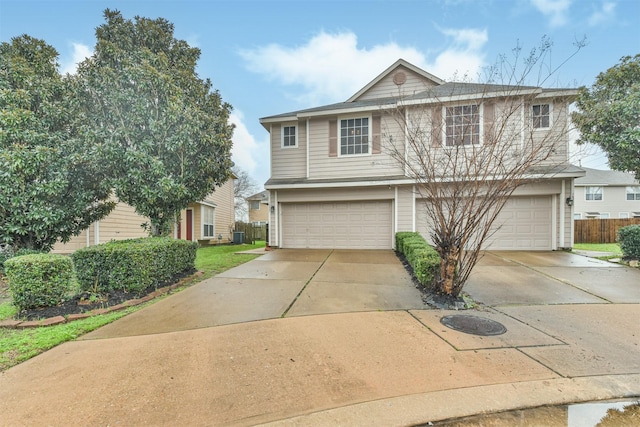 traditional-style home with concrete driveway, fence, and an attached garage