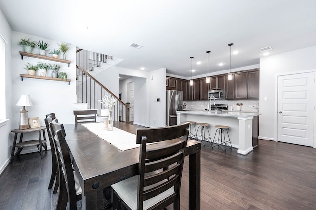 dining space featuring dark wood-type flooring and sink