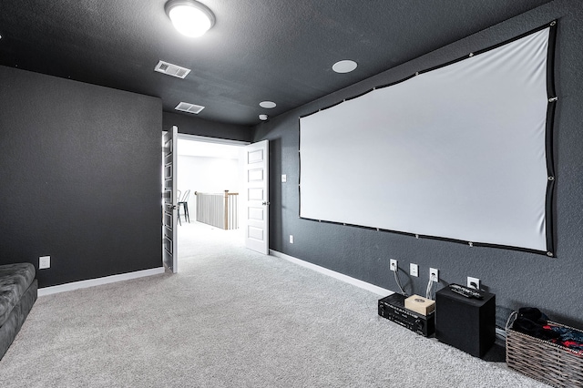 carpeted home theater featuring a textured ceiling