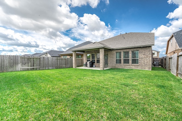 back of property with a lawn and a patio