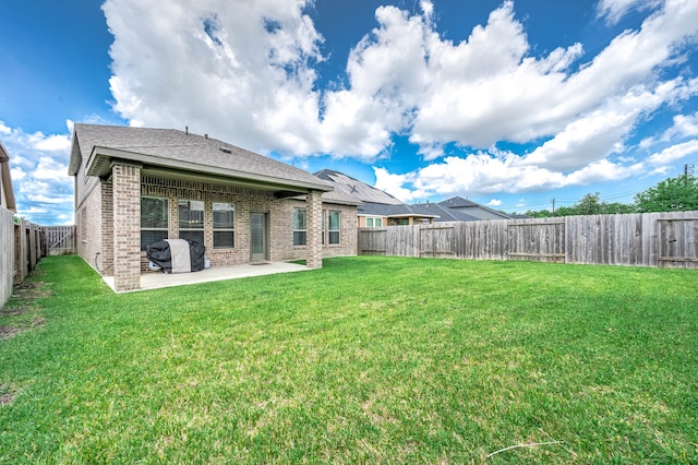 rear view of property featuring a lawn and a patio