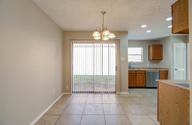 kitchen featuring a textured ceiling, dishwasher, a notable chandelier, and hanging light fixtures