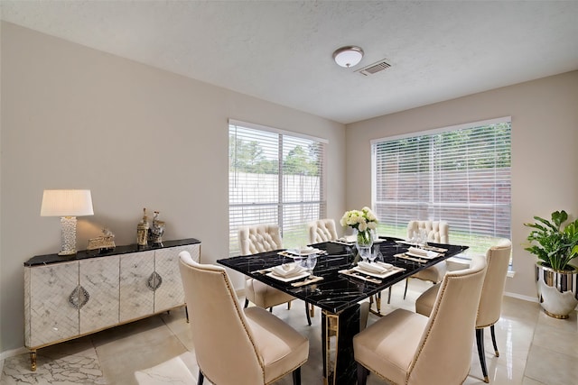 tiled dining space with a textured ceiling