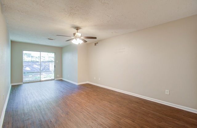 empty room featuring dark hardwood / wood-style flooring, ceiling fan, and a textured ceiling