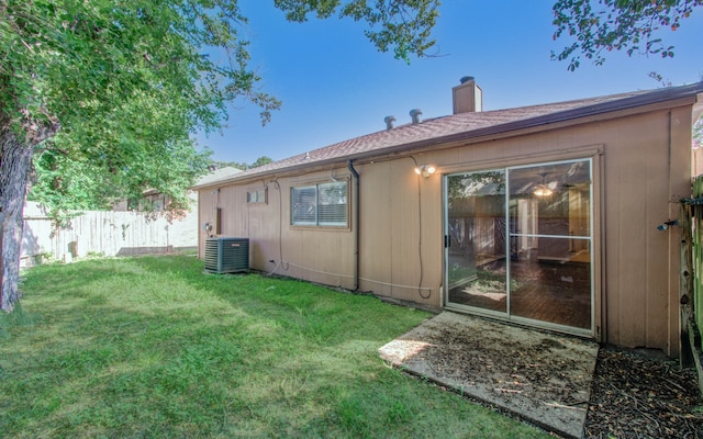 rear view of house with a lawn and central air condition unit