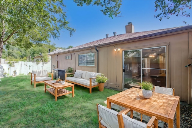 back of house with a yard and outdoor lounge area